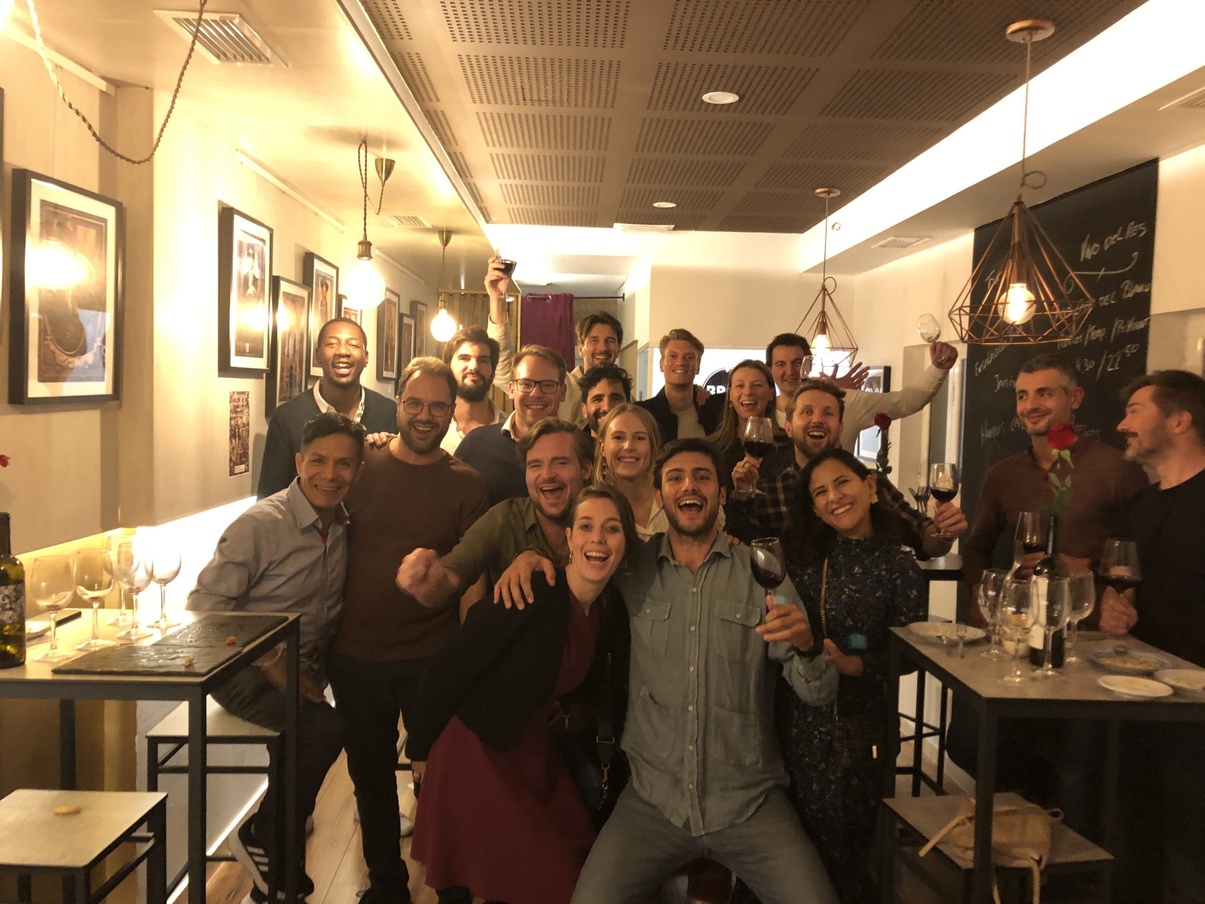 Group of people posing together in a warmly lit room.